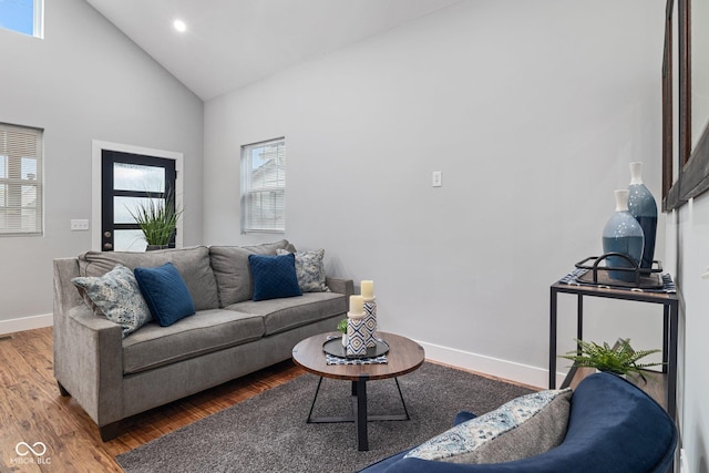 living room featuring wood finished floors, high vaulted ceiling, baseboards, and recessed lighting