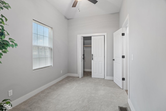 unfurnished bedroom featuring visible vents, light colored carpet, baseboards, and ceiling fan