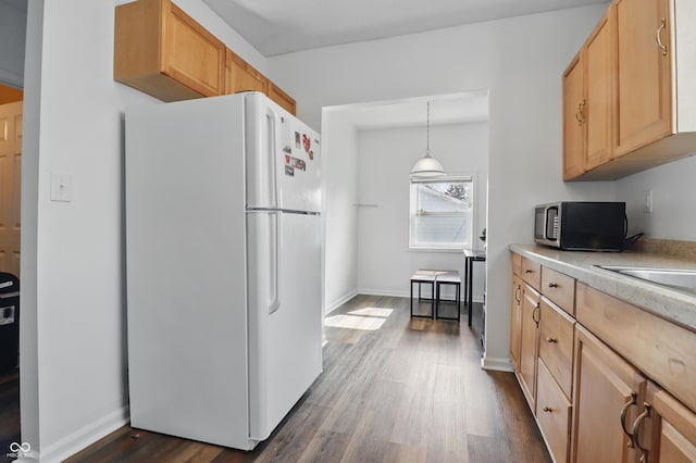 443 N Alton Ave, Indianapolis, IN 46222 - kitchen featuring freestanding refrigerator, stainless steel microwave, dark wood-type flooring, light countertops, and baseboards