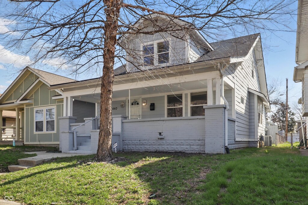 443 N Alton Ave, Indianapolis, IN 46222 - bungalow with covered porch, a front yard, and brick siding