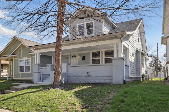 443 N Alton Ave, Indianapolis, IN 46222 - bungalow with covered porch, a front yard, and brick siding