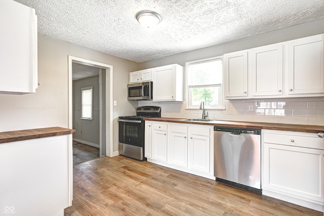 6189 Vigo Dr, Clayton, IN 46118 - kitchen featuring stainless steel appliances, wood counters, light wood finished floors, white cabinetry, and a textured ceiling