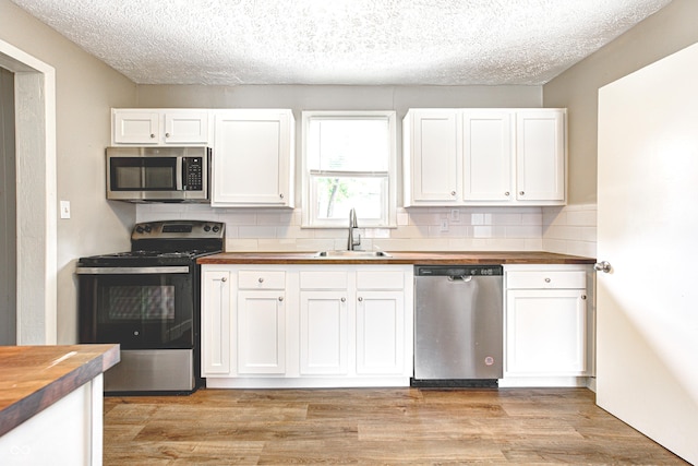6189 Vigo Dr, Clayton, IN 46118 - kitchen with stainless steel appliances, wood counters, white cabinetry, and a textured ceiling