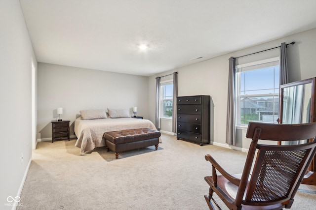 bedroom featuring light colored carpet, baseboards, and visible vents