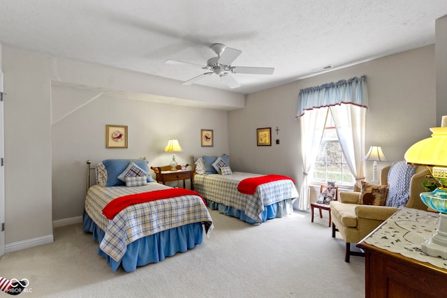 carpeted bedroom featuring a textured ceiling, visible vents, and ceiling fan