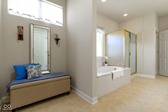 bathroom with a garden tub, baseboards, and a stall shower