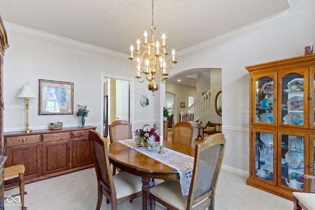 dining area featuring an inviting chandelier, ornamental molding, light colored carpet, arched walkways, and stairs