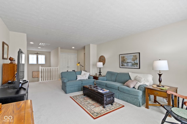 living area featuring visible vents, a textured ceiling, recessed lighting, and carpet flooring