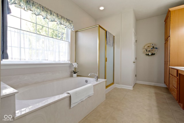 bathroom with a shower stall, a bath, vanity, baseboards, and tile patterned flooring
