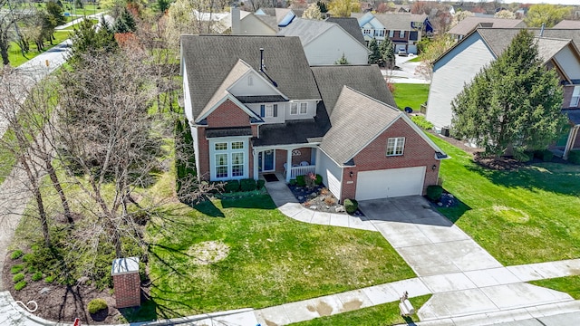 traditional home featuring concrete driveway, a front lawn, brick siding, and a garage