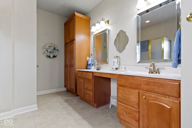 bathroom with a shower with shower door, tile patterned flooring, double vanity, a sink, and baseboards