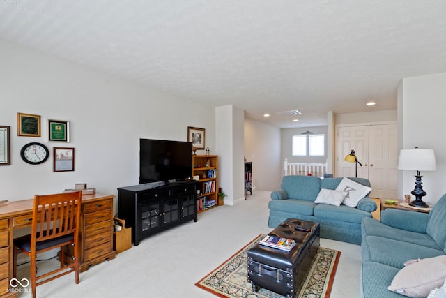 living room with recessed lighting, a textured ceiling, visible vents, and carpet