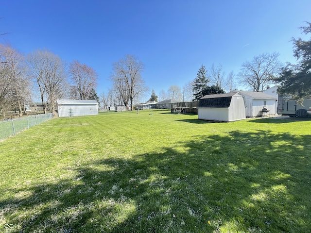 view of yard featuring a fenced backyard, an outdoor structure, and a storage unit