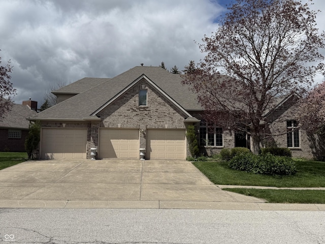 view of front of house with driveway, roof with shingles, brick siding, a front lawn, and an attached garage