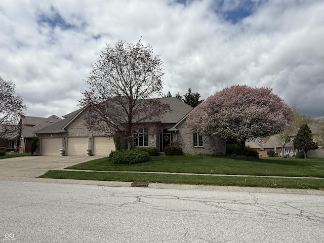 single story home featuring an attached garage, concrete driveway, a front lawn, and brick siding