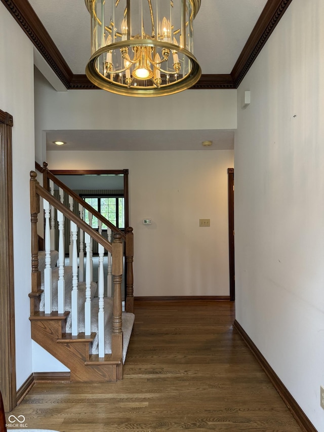 foyer with baseboards, ornamental molding, and wood finished floors