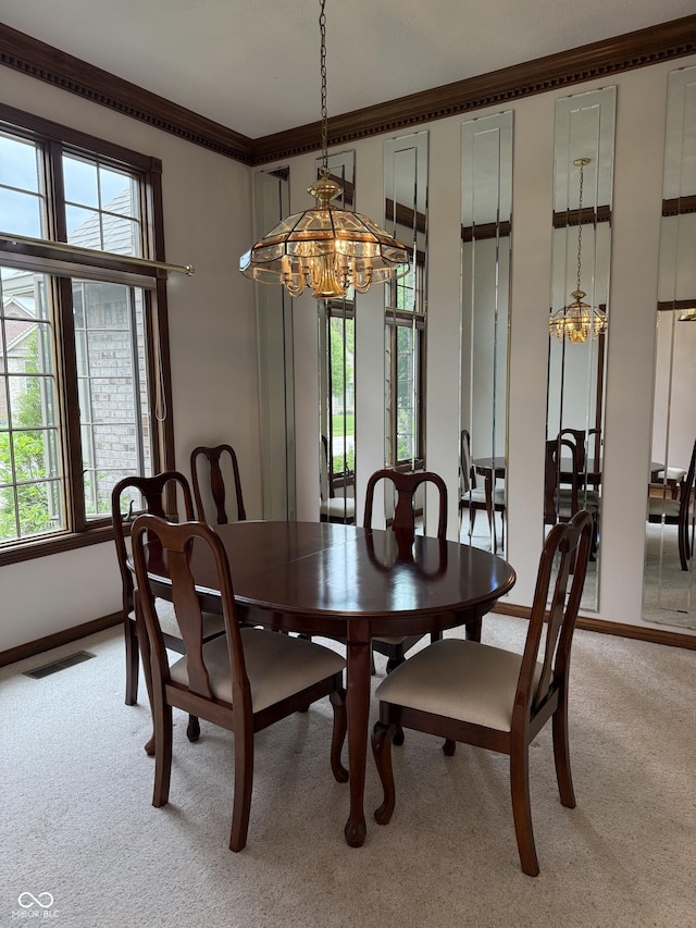 dining space featuring crown molding, light colored carpet, a chandelier, baseboards, and visible vents