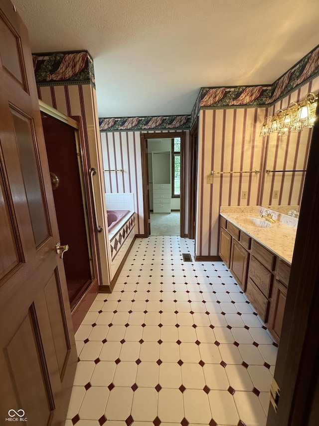 full bathroom with tile patterned floors, vanity, wallpapered walls, and a bath