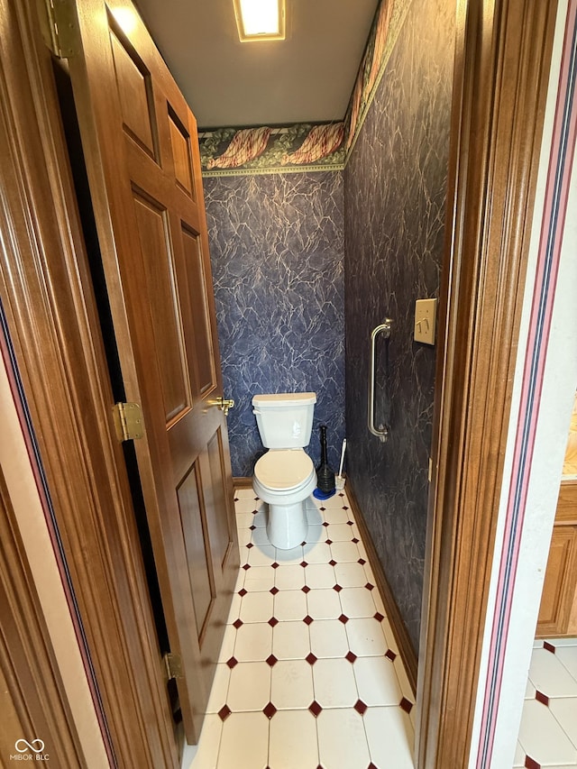 bathroom featuring toilet, tile patterned floors, and wallpapered walls