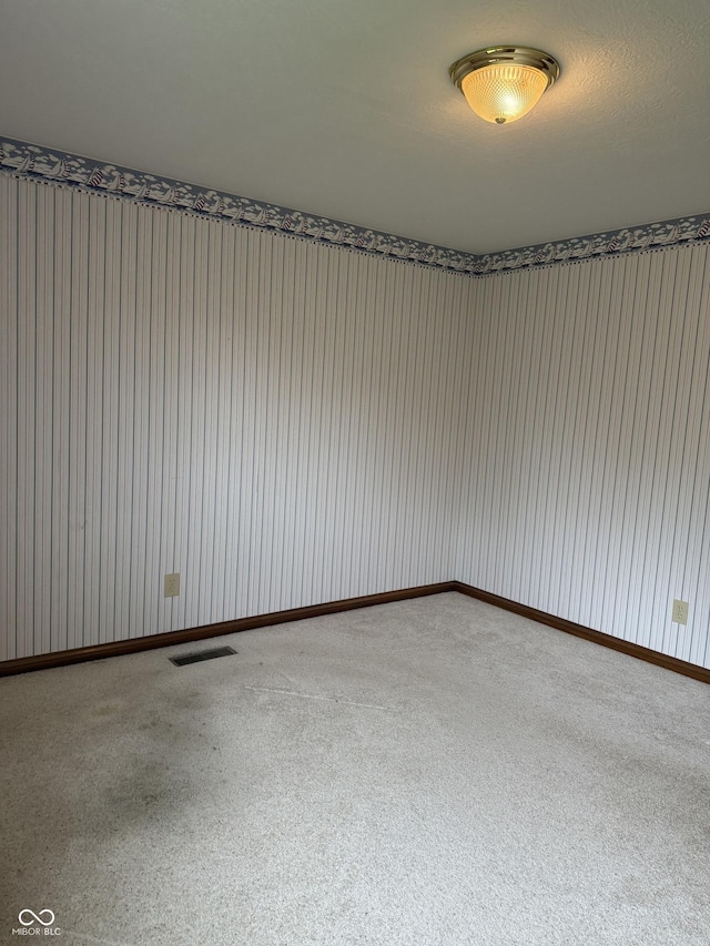 spare room featuring carpet floors and visible vents
