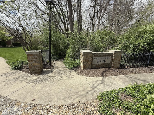 community / neighborhood sign featuring fence