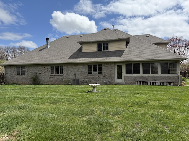 rear view of property featuring a yard and brick siding