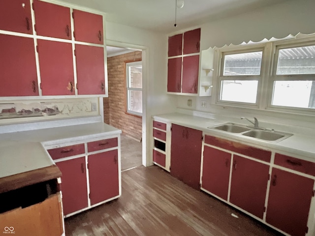 kitchen with red cabinets, dark wood-style flooring, open shelves, a sink, and light countertops