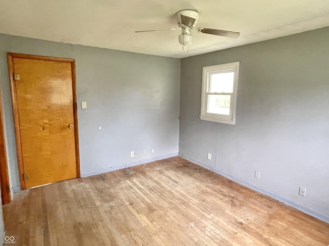 spare room featuring light wood-type flooring, baseboards, and ceiling fan