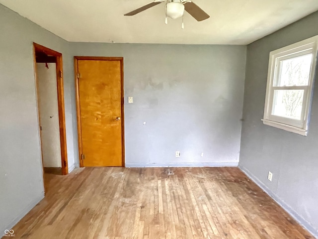 empty room featuring baseboards, ceiling fan, and wood finished floors