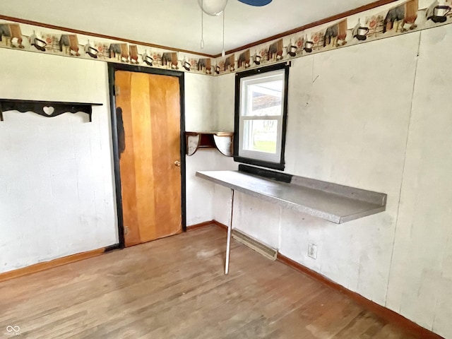 unfurnished dining area with baseboards and wood finished floors