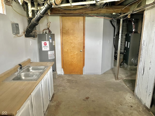 unfinished basement featuring a sink, heating unit, and electric water heater