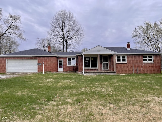 single story home with brick siding, an attached garage, a front yard, and a chimney