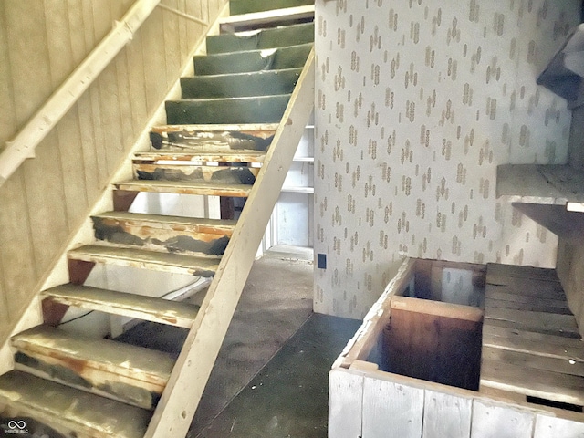 stairs featuring wallpapered walls