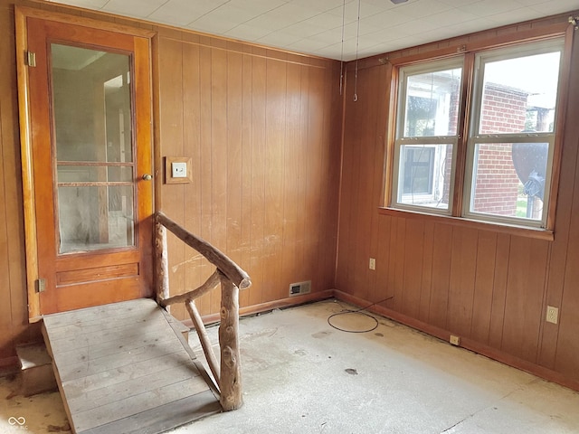 spare room with wood walls and visible vents
