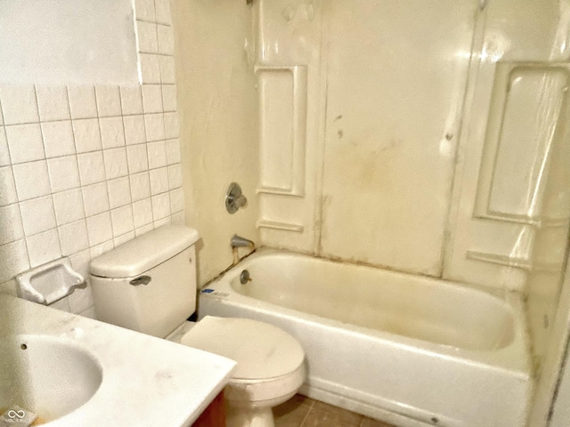 full bathroom with tile walls, tile patterned flooring, bathtub / shower combination, vanity, and toilet
