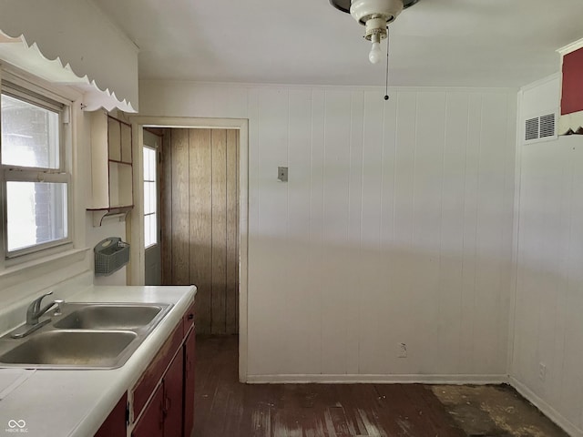 kitchen with a sink, dark wood finished floors, a ceiling fan, and light countertops