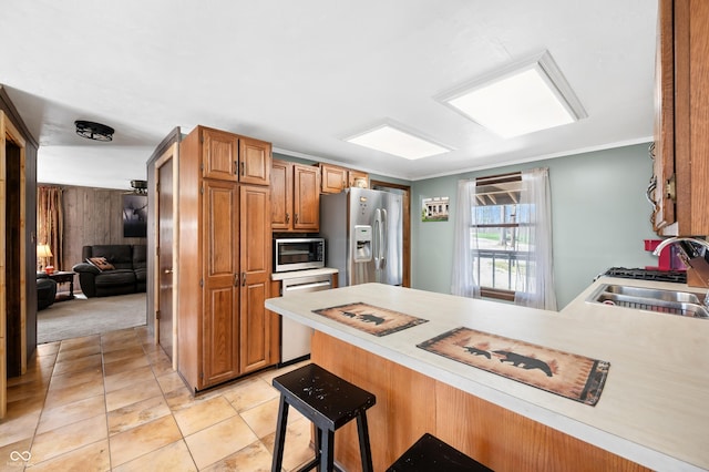 8847 E Northshore Dr, Unionville, IN 47468 - kitchen with a sink, light countertops, a kitchen bar, a peninsula, and stainless steel appliances
