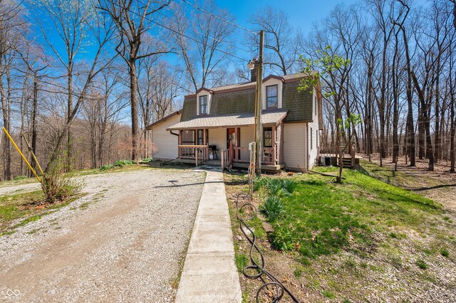 8847 E Northshore Dr, Unionville, IN 47468 - view of front of home with roof with shingles, a chimney, dirt driveway, a porch, and a gambrel roof