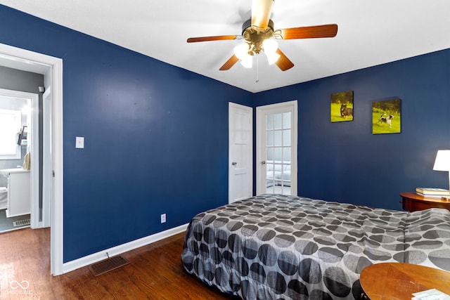 bedroom featuring baseboards, wood finished floors, visible vents, and a ceiling fan