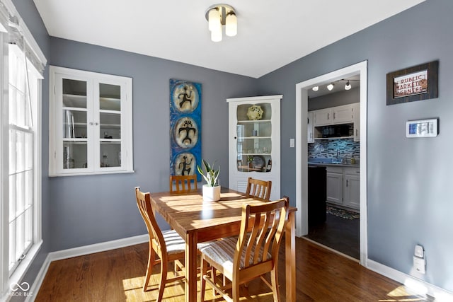 dining space with baseboards and dark wood-style floors