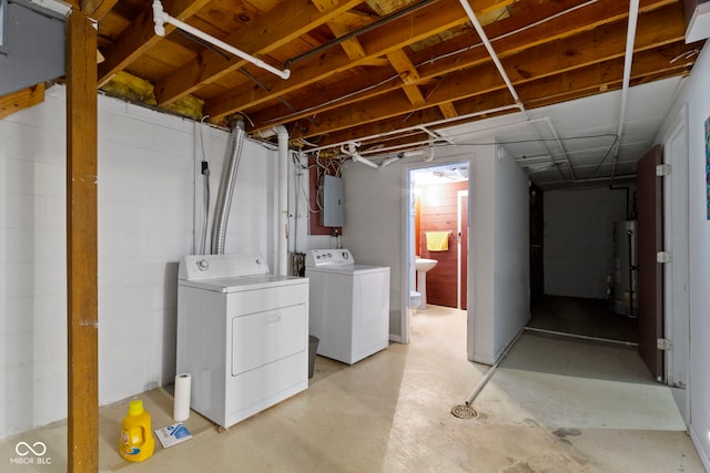 basement featuring separate washer and dryer, electric panel, and gas water heater