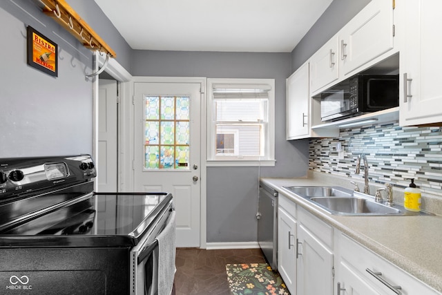 kitchen featuring tasteful backsplash, stainless steel appliances, light countertops, and a sink
