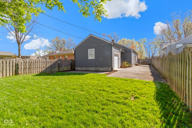 rear view of house with a fenced backyard, a yard, and a patio