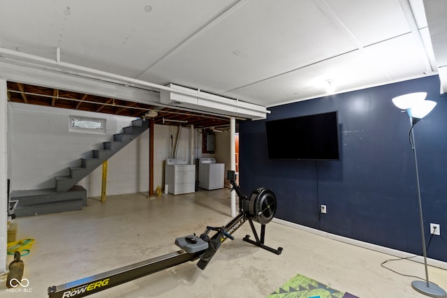 exercise area featuring electric panel and washer and clothes dryer