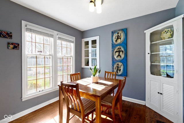 dining space featuring a healthy amount of sunlight, baseboards, and dark wood-style flooring