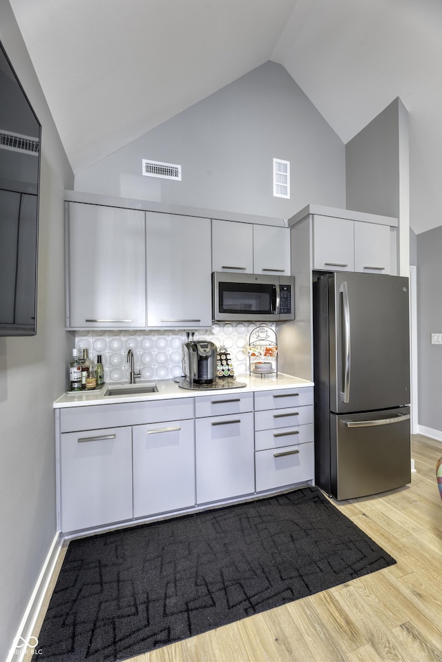 kitchen featuring visible vents, a sink, light countertops, and stainless steel appliances