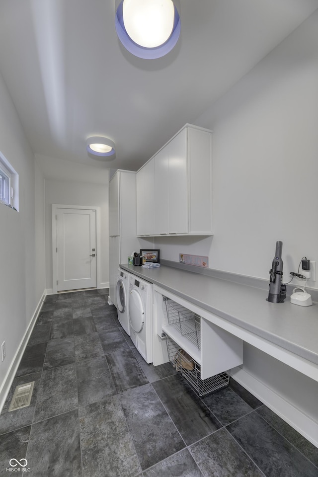 laundry area featuring baseboards, visible vents, cabinet space, and washer and clothes dryer
