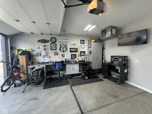 garage featuring baseboards, a workshop area, and a garage door opener