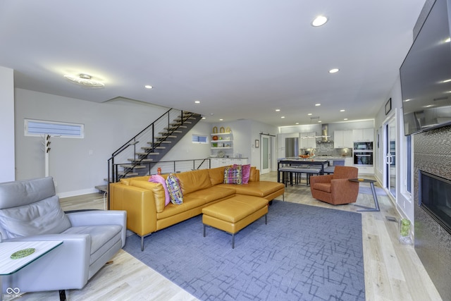 living room with stairs, recessed lighting, baseboards, and light wood finished floors