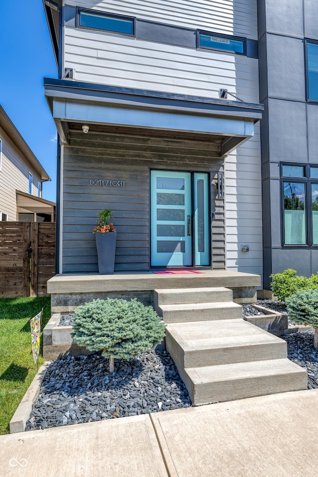 property entrance with fence and covered porch
